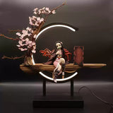 Demon Slayer Nezuko Kamado figure seated on a wooden platform with LED circular display and sakura tree, perfect for anime collectors.