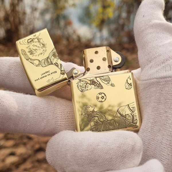 Gold Zippo lighter with deep engraving featuring Nagi Seishiro from Blue Lock, displayed open to showcase intricate artwork on both the lid and body.