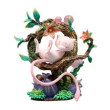 Pokémon Mew figure with LED light, sitting on a tree branch surrounded by colorful flowers.