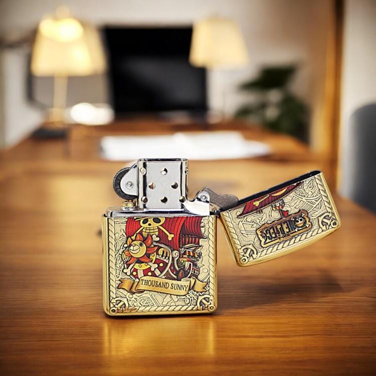 Open brass lighter featuring Thousand Sunny from One Piece - collectible for anime fans